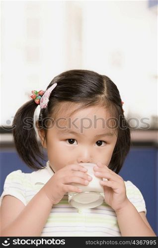 Portrait of a girl drinking milk from a glass