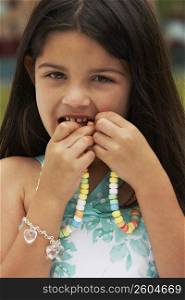 Portrait of a girl eating a candy necklace