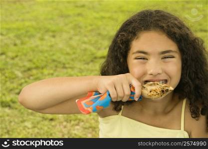 Portrait of a girl eating a chicken drumstick