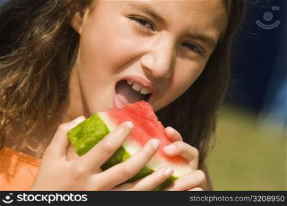 Portrait of a girl eating a slice of a watermelon