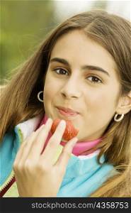 Portrait of a girl eating a strawberry
