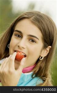 Portrait of a girl eating a strawberry