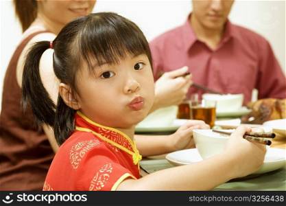Portrait of a girl eating with chopsticks