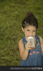 Portrait of a girl holding a baby bottle