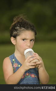 Portrait of a girl holding a baby bottle