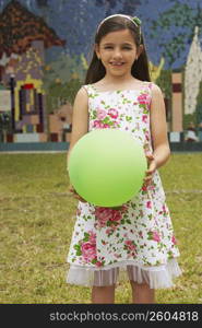 Portrait of a girl holding a balloon in a park