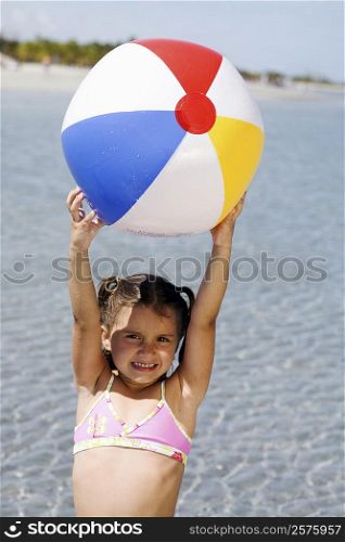 Portrait of a girl holding a beach ball on the beach