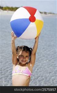 Portrait of a girl holding a beach ball on the beach