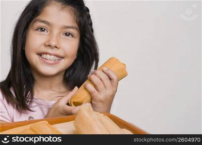 Portrait of a girl holding a bread and smiling in the kitchen
