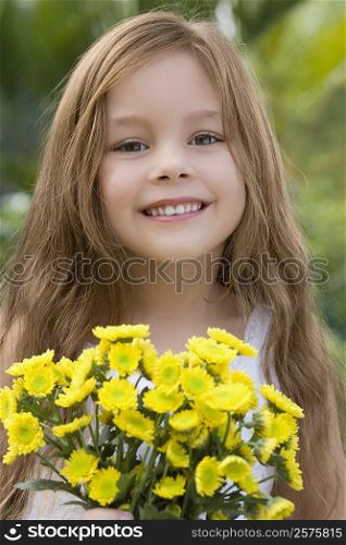 Portrait of a girl holding a bunch of flowers and smiling