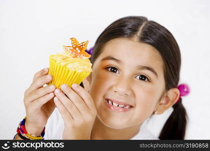 Portrait of a girl holding a cupcake