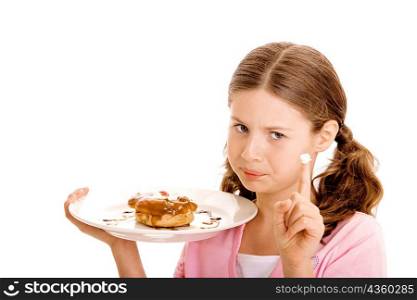 Portrait of a girl holding a donut in a plate with cream on the tip of her finger