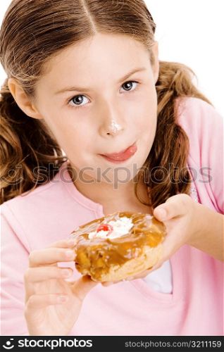 Portrait of a girl holding a donut licking her lips