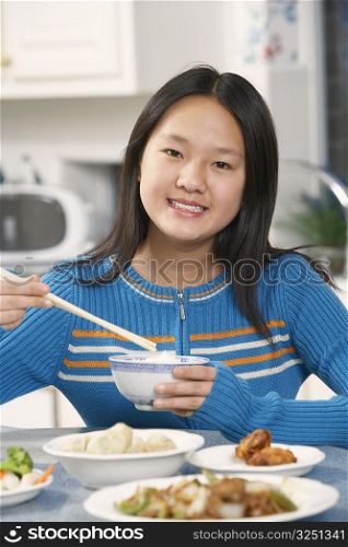 Portrait of a girl holding a pair of chopsticks and a bowl