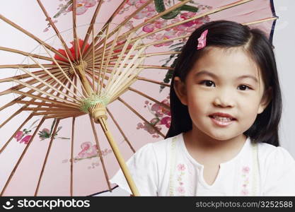 Portrait of a girl holding a parasol and smiling