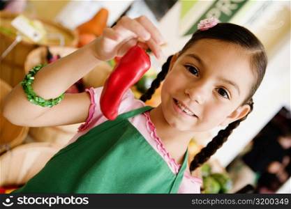 Portrait of a girl holding a red chili pepper