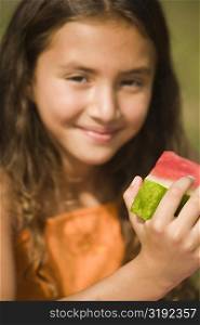 Portrait of a girl holding a slice of a watermelon