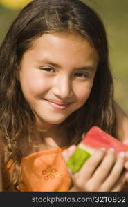 Portrait of a girl holding a slice of a watermelon