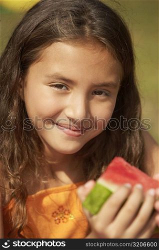 Portrait of a girl holding a slice of watermelon
