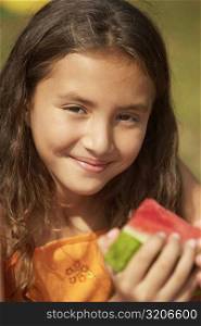 Portrait of a girl holding a slice of watermelon