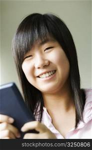 Portrait of a girl holding a video game and smiling
