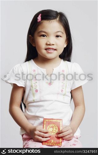 Portrait of a girl holding an envelope and smiling