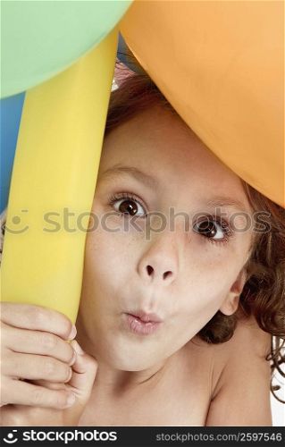 Portrait of a girl holding balloons and puckering her lips
