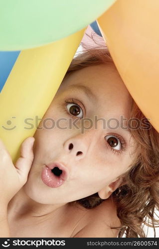 Portrait of a girl holding balloons and puckering her lips