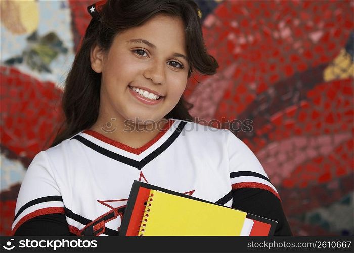 Portrait of a girl holding books and smiling