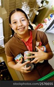 Portrait of a girl holding cans and smiling