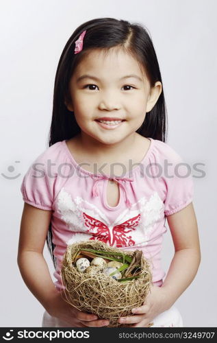 Portrait of a girl holding eggs in a bird&acute;s nest