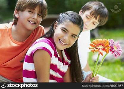 Portrait of a girl holding flowers and smiling with her friends