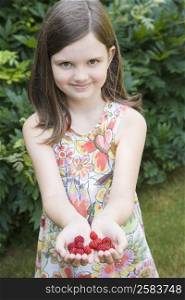 Portrait of a girl holding raspberries