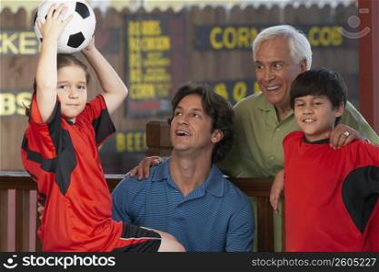 Portrait of a girl holding up a soccer ball with her family beside her in a restaurant
