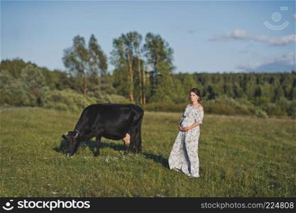 Portrait of a girl in a closed dress standing near a cow in a meadow.. A village girl near a grazing cow 1754.