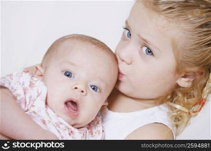Portrait of a girl kissing her sister