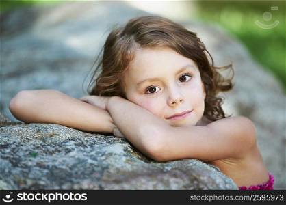 Portrait of a girl leaning on a rock