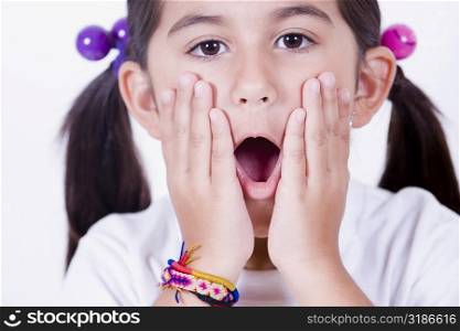 Portrait of a girl looking surprised with her hands on her face