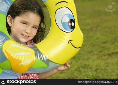 Portrait of a girl looking through an inflatable ring