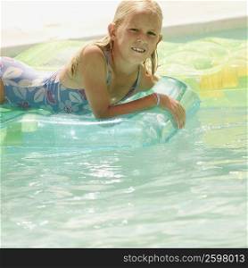 Portrait of a girl lying on a pool raft