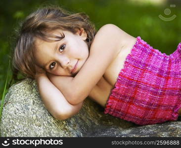 Portrait of a girl lying on a rock