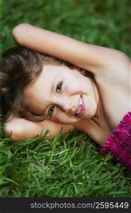 Portrait of a girl lying on the grass and smiling