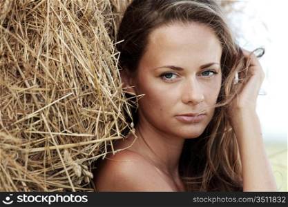 portrait of a girl next to haystack close