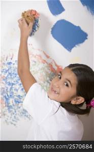 Portrait of a girl painting a wall with a sponge