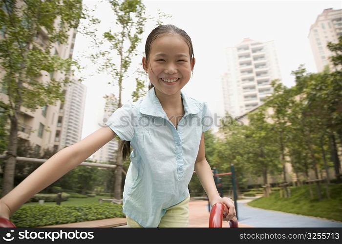 Portrait of a girl playing on a merry-go-round and smiling