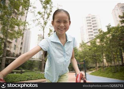 Portrait of a girl playing on a merry-go-round and smiling