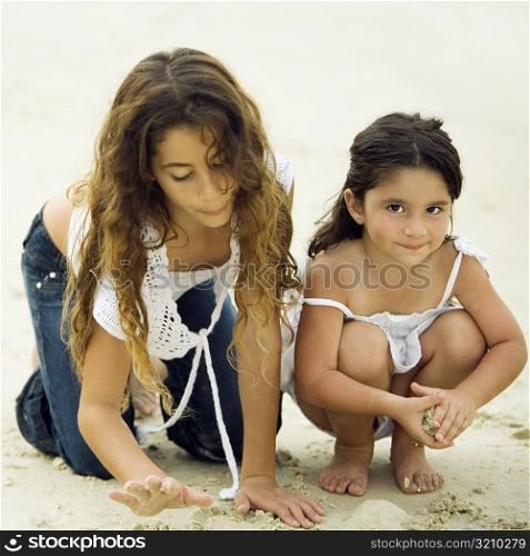 Portrait of a girl playing with her sister on the beach