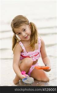 Portrait of a girl playing with toys on the beach