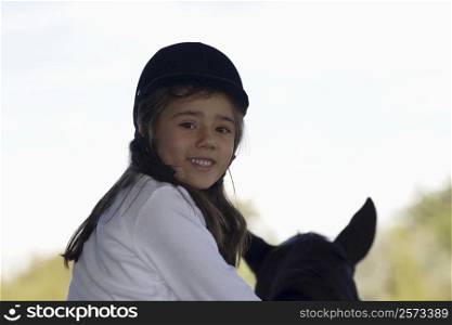 Portrait of a girl riding a horse and smiling