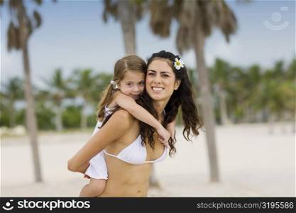 Portrait of a girl riding piggyback on her mother